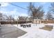 Snowy backyard with patio, shed, and seating area at 5454 Clay St, Denver, CO 80221