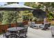 Enjoy this outdoor space with an umbrella-covered table and swivel chairs around a gas fire pit at 7836 S Fairfax Ct, Centennial, CO 80122