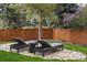 Serene backyard retreat with lounge chairs, a wooden fence, and ambient string lights at 7836 S Fairfax Ct, Centennial, CO 80122