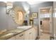 Elegant bathroom with a decorative mirror, marble countertop, and a tiled shower at 7836 S Fairfax Ct, Centennial, CO 80122