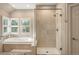 Bright bathroom featuring a tub and a stand-up shower with a glass enclosure with bronze finishings at 7836 S Fairfax Ct, Centennial, CO 80122
