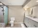 Well-lit bathroom with a glass shower, toilet, vanity, sink, and a tiled floor for modern comfort at 7836 S Fairfax Ct, Centennial, CO 80122