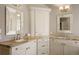Bright bathroom features dual sinks with granite countertops, decorative mirrors, and custom white cabinetry at 7836 S Fairfax Ct, Centennial, CO 80122