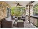 Relaxing covered porch with comfortable seating, ceiling fan, and stone detailing, perfect for outdoor enjoyment at 7836 S Fairfax Ct, Centennial, CO 80122