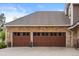Spacious three car garage features custom wood doors with decorative brick and stone masonry at 7836 S Fairfax Ct, Centennial, CO 80122