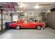 Epoxy floor in a well organized garage with slat wall, storage racks and a red classic car at 7836 S Fairfax Ct, Centennial, CO 80122
