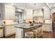 An open kitchen boasts custom cabinets, pendant lighting, and a center island with stool seating at 7836 S Fairfax Ct, Centennial, CO 80122