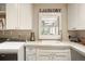 Bright laundry room features white cabinetry, marble countertops, stainless steel faucet and modern washer and dryer at 7836 S Fairfax Ct, Centennial, CO 80122