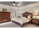 Well lit main bedroom showcases a dark wood furniture set, ceiling fan, and plush carpeting at 7836 S Fairfax Ct, Centennial, CO 80122