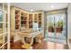 Office space with built-in bookshelves, a large desk, and access to a private outdoor patio at 7836 S Fairfax Ct, Centennial, CO 80122