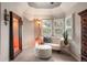 Cozy sitting area features a comfortable chair, large mirror, and ample natural light through shuttered windows at 7836 S Fairfax Ct, Centennial, CO 80122