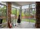 Bright sun room featuring stone accent walls and large windows with a view of the yard and surrounding neighborhood at 7836 S Fairfax Ct, Centennial, CO 80122
