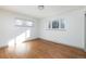 Bright bedroom with hardwood floors and plenty of natural light from two large windows at 3640 Elm St, Denver, CO 80207