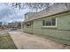 View of the side of the home with brickwork, windows, and a spacious driveway at 3640 Elm St, Denver, CO 80207