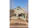 Light green two-story home showcasing a front yard with a walkway leading to a green front door at 3640 Elm St, Denver, CO 80207