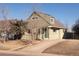 Light green two-story home featuring brick and vinyl siding and a driveway leading up to the house at 3640 Elm St, Denver, CO 80207