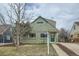 Charming two-story home with a green exterior, well-maintained lawn, and inviting front entrance at 3640 Elm St, Denver, CO 80207