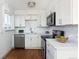 Modern kitchen with stainless steel appliances, white cabinetry, and subway tile backsplash at 3640 Elm St, Denver, CO 80207