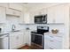 Well-lit kitchen featuring stainless steel appliances, white cabinetry, and ample counter space at 3640 Elm St, Denver, CO 80207