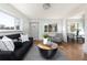 Comfortable living room with a large window, gray sofa, patterned chairs, and hardwood floors at 3640 Elm St, Denver, CO 80207