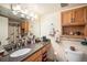 Bathroom featuring vanity with granite countertop, framed mirror, overhead lighting and bath accessories at 12151 Melody Dr # 202, Westminster, CO 80234