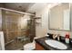 Bathroom featuring tiled walk-in shower with seat, vanity and framed mirror, and modern sink at 12151 Melody Dr # 202, Westminster, CO 80234