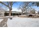 Exterior view of the clubhouse/office, enhanced by mature trees and snow covered ground at 7877 E Mississippi Ave # 1107, Denver, CO 80247