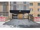 The condo entrance with a bronze door shows signage and brick features around the covered entry at 7877 E Mississippi Ave # 1107, Denver, CO 80247