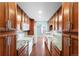 A galley kitchen featuring granite countertops, backsplash, wood cabinets, and stainless steel appliances at 7877 E Mississippi Ave # 1107, Denver, CO 80247