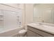 Bright bathroom features a single sink vanity and a shower-tub combination with white tile surround at 845 Leeward St, Lochbuie, CO 80603