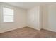 Cozy bedroom featuring neutral carpet, a window for natural light, and a white door at 845 Leeward St, Lochbuie, CO 80603