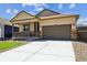 Inviting home exterior featuring a well-maintained lawn, covered porch, and a convenient two-car garage at 845 Leeward St, Lochbuie, CO 80603