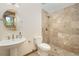 Bathroom featuring a pedestal sink, toilet, and a tiled walk-in shower, providing a sleek and modern space at 10592 Raven Run, Littleton, CO 80125
