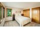 Cozy bedroom with a queen-size bed, wood-framed windows overlooking trees, and ample closet space at 10592 Raven Run, Littleton, CO 80125