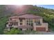 Striking two-story home featuring large windows, balconies, and a red tile roof, offering abundant natural light at 10592 Raven Run, Littleton, CO 80125