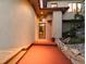 Unique front entrance featuring an orange walkway, garden with Buddha statue, and glass door at 10592 Raven Run, Littleton, CO 80125