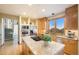 Well-lit kitchen with granite countertops, island gas cooktop, stainless appliances, and breakfast bar at 10592 Raven Run, Littleton, CO 80125