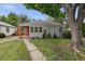 Charming single-story home with a gray exterior, orange entryway, and mature tree shading the front yard at 2709 S Franklin St, Denver, CO 80210