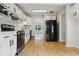 Bright kitchen features stainless steel appliances, white cabinetry, and beautiful hardwood floors at 2709 S Franklin St, Denver, CO 80210