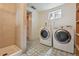 Laundry room with a modern washer and dryer set and a tiled shower at 2709 S Franklin St, Denver, CO 80210