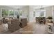 Open-concept living space with hardwood floors, large windows, and a dining area. Virtually staged at 2709 S Franklin St, Denver, CO 80210