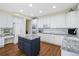 Updated kitchen with white cabinets, granite countertops, and a center island with dark blue cabinetry at 87 Canongate Ln, Highlands Ranch, CO 80130