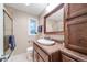 Bathroom with a single sink vanity, a shower with glass door, and natural light from a window at 245 Main St, Broomfield, CO 80020