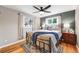 Comfortable bedroom featuring hardwood floors, a ceiling fan, a cast iron bed frame, and natural light at 245 Main St, Broomfield, CO 80020