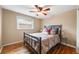 Inviting bedroom with hardwood floors, a ceiling fan, a cast iron bed frame, and natural light at 245 Main St, Broomfield, CO 80020