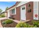 Close-up of the brick facade, front door, and meticulously landscaped garden bed at 245 Main St, Broomfield, CO 80020