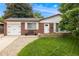 Charming brick home featuring a well-manicured lawn, stone garden bed, and attached garage at 245 Main St, Broomfield, CO 80020