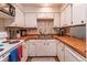 Cozy kitchen featuring classic white cabinetry, wood countertops, and essential appliances, ready for home cooking at 7945 York St # 2, Denver, CO 80229