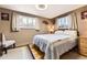 Bedroom with neutral color scheme, natural light, hardwood floors, and a patterned quilt at 8375 W 17Th W Ave, Lakewood, CO 80214