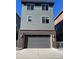 Three-story home featuring gray siding, a brick foundation, and an attached two-car garage at 2383 S Troy Ct, Aurora, CO 80014